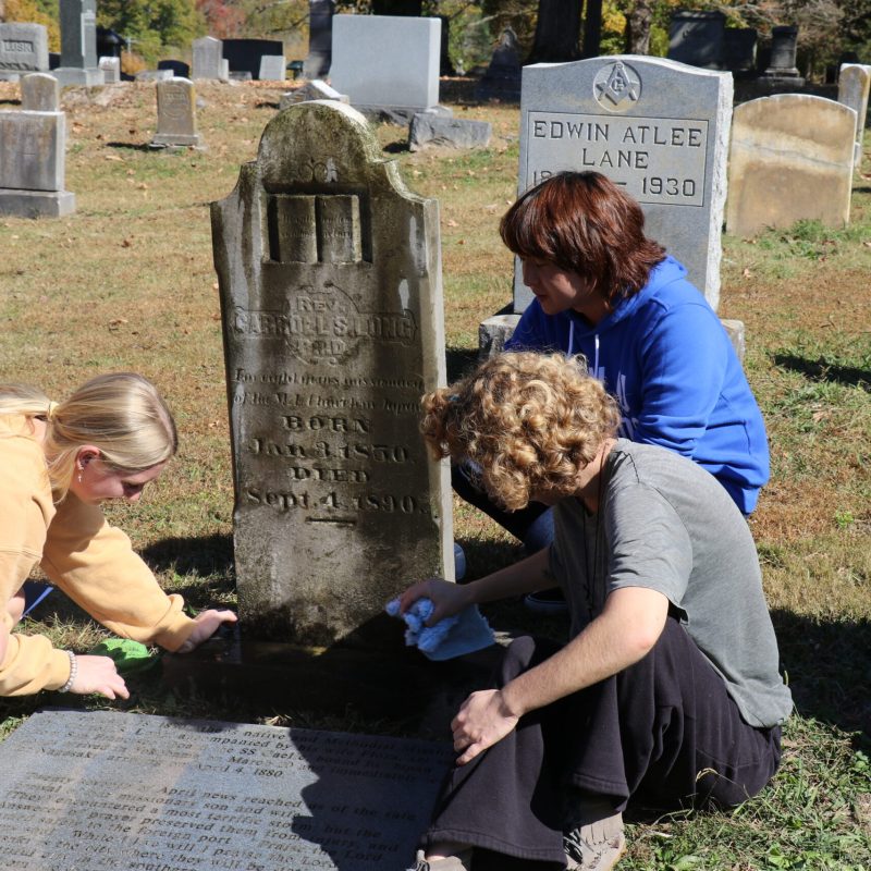 wesleyan students cleaning grave