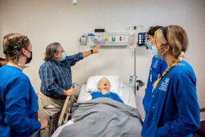 Three Tennessee Wesleyan nursing students learning with their professor