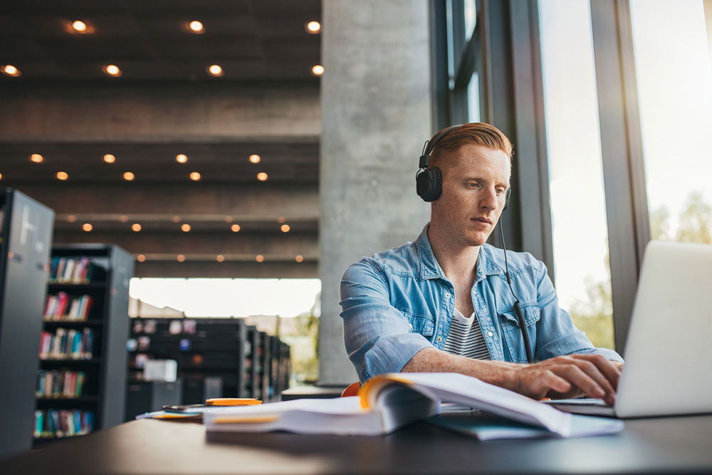 student studying in building with headphones