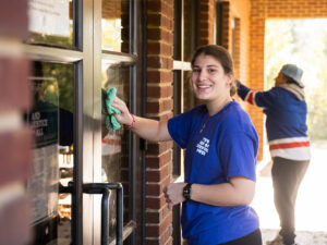 Young TWU female student cleaning windows