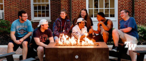 Group of Tennessee Wesleyan students in front of campfire at Sherman dining hall.