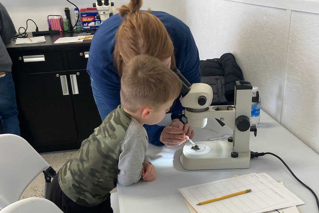 Young student and teacher looking through a microscope