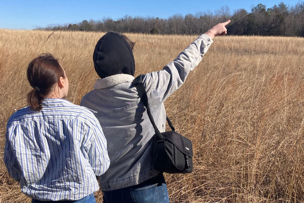 Two TWU students pointing over the grasslands
